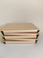 One More Chapter Premium Kindle Case in Barista Blend – five cases stacked flat, warm cream and taupe stripe, top-down view