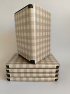 One More Chapter Premium Kindle Case in Booked for Brunch – open folio standing upright on stack of closed cases, sage and cream gingham