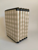 One More Chapter Premium Kindle Case in Booked for Brunch – multiple sage and cream gingham folios fanned upright, angled back view