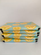 One More Chapter Premium Kindle Case in Lemon Grove – five sky blue lemon slice print folios stacked flat, side-on view