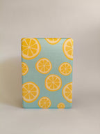 One More Chapter Premium Kindle Case in Lemon Grove – closed folio standing upright, sky blue with lemon slice print, front view