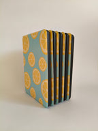 One More Chapter Premium Kindle Case in Lemon Grove – five sky blue lemon slice print folios fanned upright, spine-side view, front facing