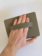 One More Chapter Premium Kindle Case in Booked for Brunch – hand gripping back hand strap, showing secure hold