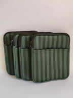One More Chapter E-reader Sleeve in Midnight Library – four deep forest green tonal stripe padded sleeves lined up, angled front view showing front pocket and dark zip
