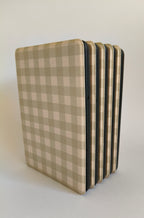 One More Chapter Premium Kindle Case in Booked for Brunch – sage and cream gingham folio, multiple cases fanned upright, spine-side view