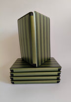One More Chapter Premium Kindle Case in Midnight Library – open folio standing upright on stack of closed cases, olive and dark green stripe