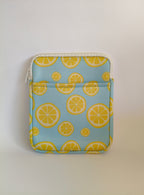 One More Chapter E-reader Sleeve in Lemon Grove – single padded sleeve front view showing front pocket, sky blue with yellow lemon slice print and white zip