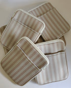 One More Chapter E-reader Sleeve in Barista Blend – multiple warm cream and taupe stripe sleeves scattered, top-down flat lay