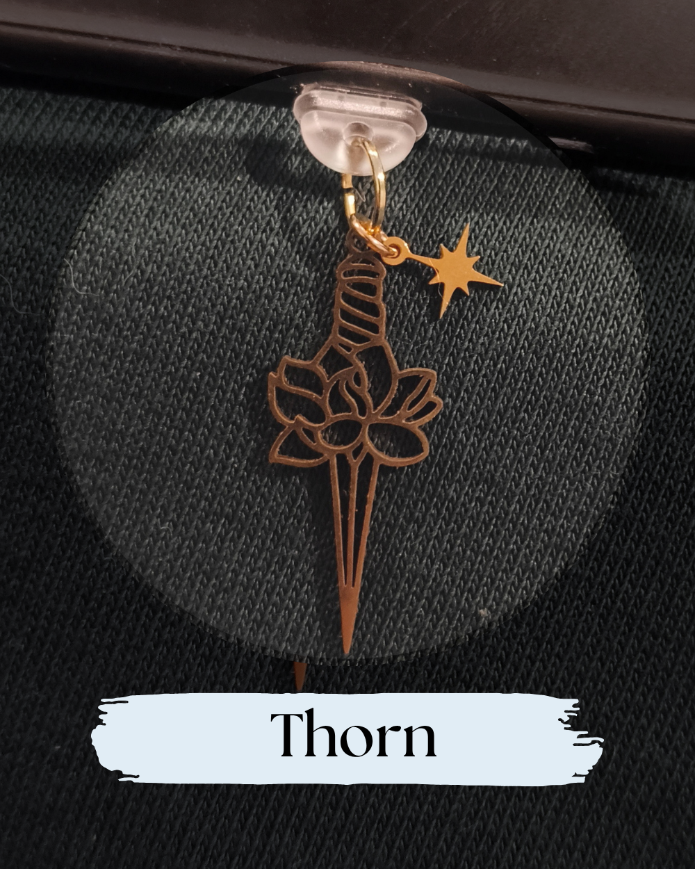 Dust plug for Kindle or e-reader, gold flower dagger, A close-up of a small metal charm shaped like a flower with a thorn stem, with celestial star charm, Kindle, Kindle Accessory, Kobo, One More Chapter